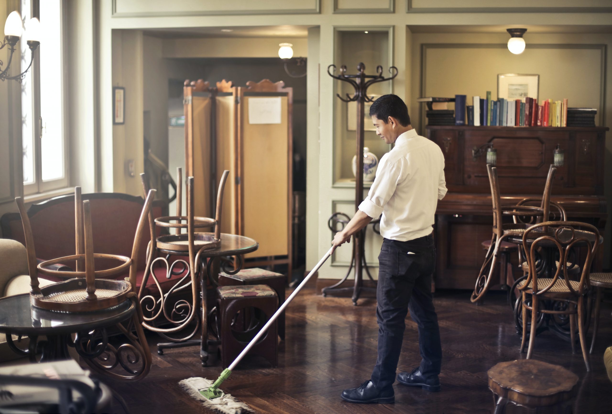 male-employee-cleaning-floor-in-restaurant-3769711